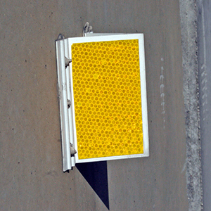 [Image Description: A Guardrail Delineator mounted on a wooden guardrail beam.]