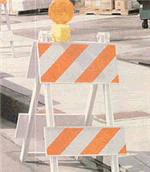 [Image Description: A white and orange striped traffic barrier]